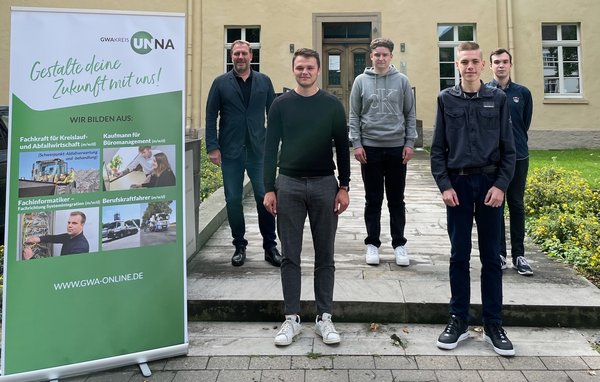 Vier Auszubildende und ihr Ausbilder stehen vor einem Haus der GWA.