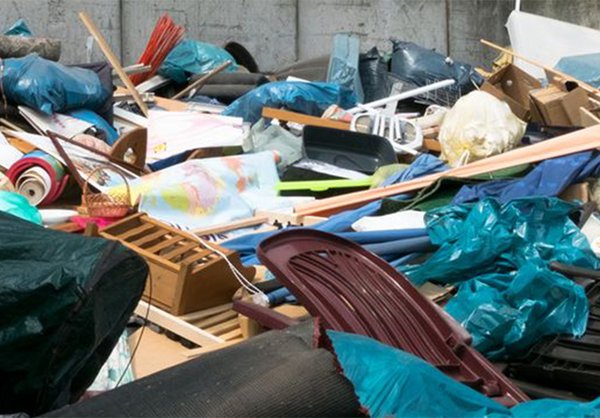 Ein Haufen Sperrmüll mit Müllsäcken, Plastikstühlen und Holzteilen