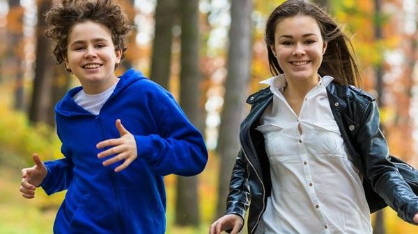 Junge und Mädchen laufen fröhlich auf den Fotografen zu.