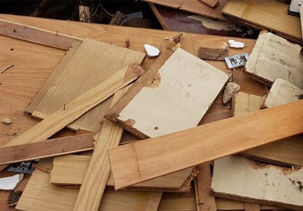 Alte Holzlatten mit Nägeln und Spanplatten liegen auf einem Haufen.